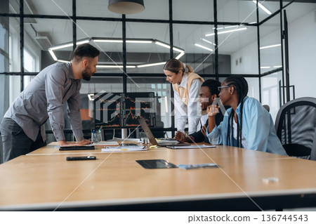 In conference room by the table. Business people are working in the office In conference room by the table. Business people are working in the office 136744543