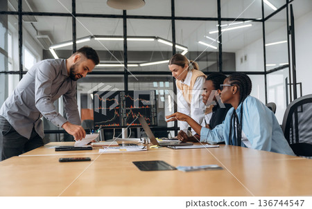 In conference room by the table. Business people are working in the office In conference room by the table. Business people are working in the office 136744547