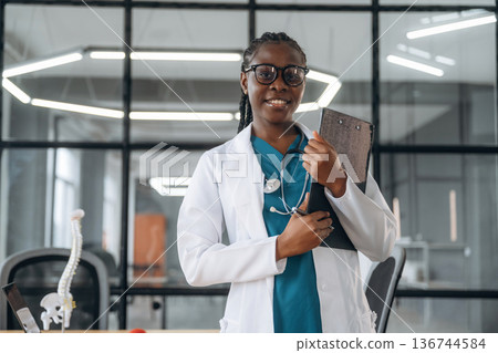 In white coat. Female doctor in coat is in the office clinic 136744584