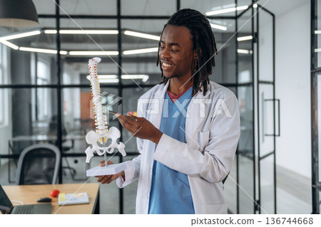 Man doctor is showing the model of human spine 136744668