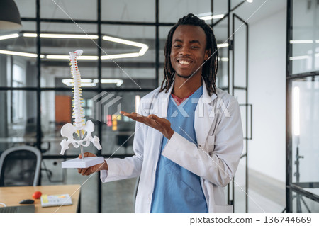 Man doctor is showing the model of human spine 136744669