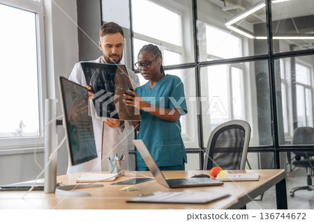 Examining the x-ray. Doctors are working in the office 136744672
