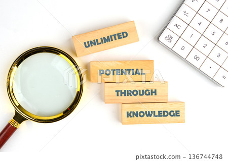 A guiding message unfolds with wooden blocks spelling Unlimited Potential Through Knowledge, set alongside a magnifying glass and a calculator on a bright desk A guiding message unfolds with wooden blocks spelling Unlimited Potential Through Knowledge, set alongside a magnifying glass and a calculator on a bright desk 136744748