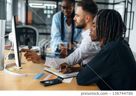 By the table together. Business people are working in the office 136744780
