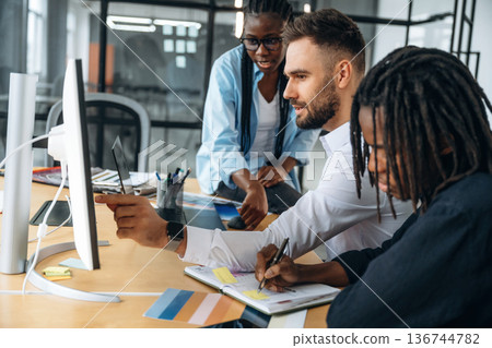 By the table together. Business people are working in the office 136744782