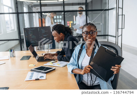 Cheerful woman is smiling. Business people are working in the office Cheerful woman is smiling. Business people are working in the office 136744794