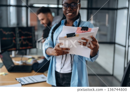 Documents in hands of a woman. Business people are working in the office Documents in hands of a woman. Business people are working in the office 136744800