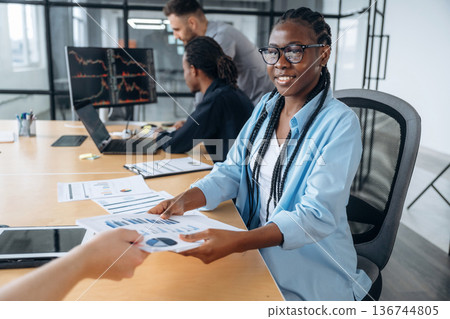 Giving the documents. Business people are working in the office Giving the documents. Business people are working in the office 136744805