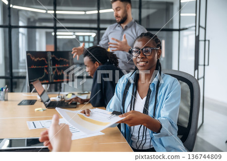 Giving the documents. Business people are working in the office Giving the documents. Business people are working in the office 136744809