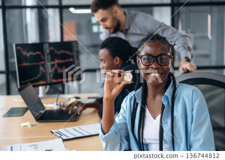 Crypto coin in hand of woman. Business people are working in the office 136744812