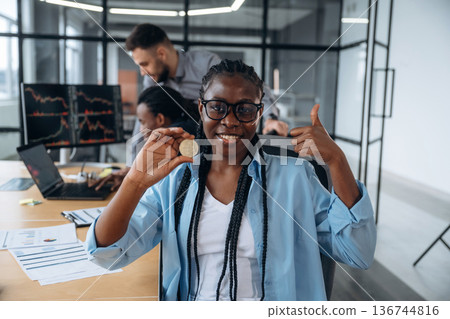 Profit of crypto, coin in hand of woman. Business people are working in the office 136744816