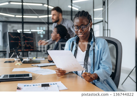 African American woman is sitting by table. Business people are working in the office African American woman is sitting by table. Business people are working in the office 136744822