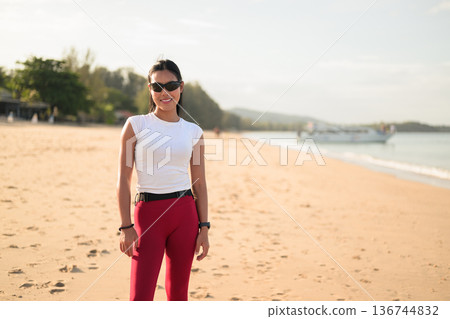 Fit Asian Woman in Sportswear Standing on Beach During Summer Workout Fit Asian Woman in Sportswear Standing on Beach During Summer Workout 136744832
