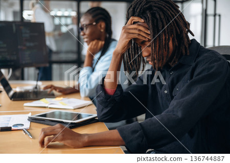 Man is tired, exhausted. Business people are working in the office Man is tired, exhausted. Business people are working in the office 136744887