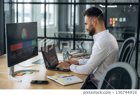 Laptop and external display. Designer is working in the office Laptop and external display. Designer is working in the office 136744919