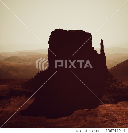 classic valley vista with towering monoliths, silhouettes of iconic rock masses against soft glowing sky and layered distant mesas creating timeless desert 136744944
