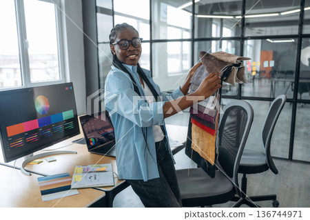 Woman is holding colorful palette. Designer is working in the office Woman is holding colorful palette. Designer is working in the office 136744971