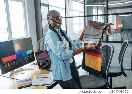 Woman is holding colorful palette. Designer is working in the office Woman is holding colorful palette. Designer is working in the office 136744972