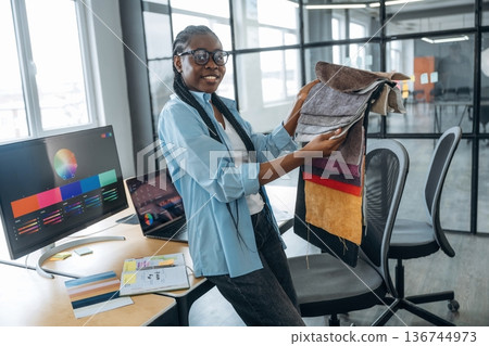 Woman is holding colorful palette. Designer is working in the office Woman is holding colorful palette. Designer is working in the office 136744973