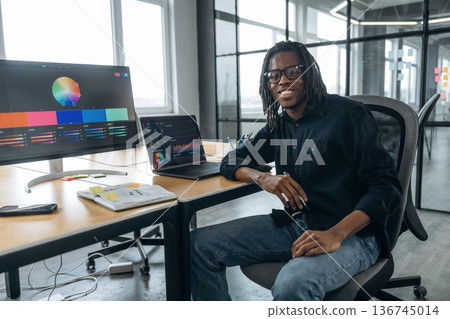Modern technology, laptop and display are on the table. Designer is working in the office Modern technology, laptop and display are on the table. Designer is working in the office 136745014