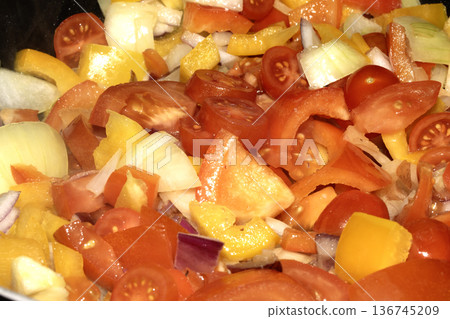 Close up of mixed fried vegetables chopped tomatoes, onions and peppers frying Close up of mixed fried vegetables chopped tomatoes, onions and peppers frying 136745209