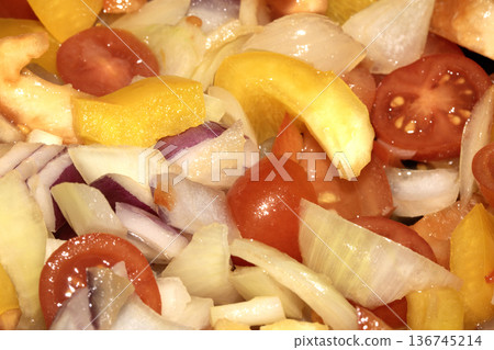Close up of mixed fried vegetables chopped tomatoes, onions and peppers frying Close up of mixed fried vegetables chopped tomatoes, onions and peppers frying 136745214