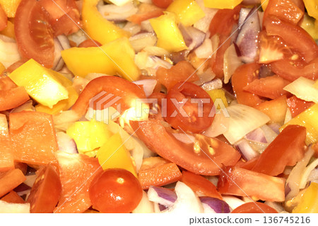 Close up of mixed fried vegetables chopped tomatoes, onions and peppers frying Close up of mixed fried vegetables chopped tomatoes, onions and peppers frying 136745216
