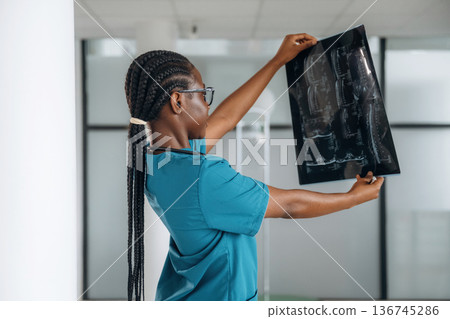 X-ray results. Female doctor is indoors in modern room 136745286