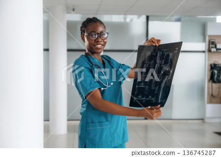 X-ray results. Female doctor is indoors in modern room X-ray results. Female doctor is indoors in modern room 136745287
