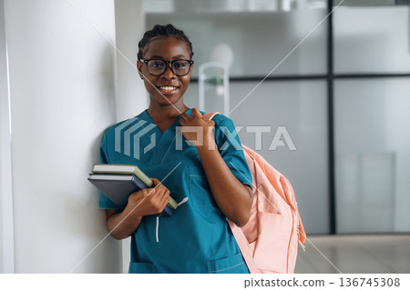 Woman student with pink backpack is indoors 136745308