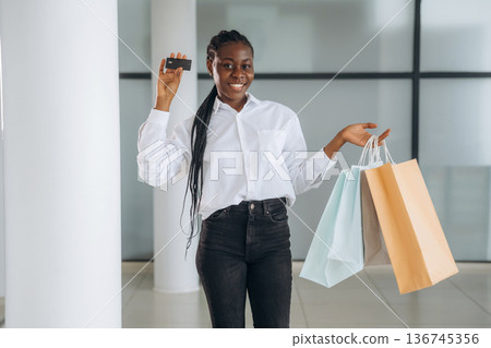 Credit card in hand, payment, shopping. Businesswoman in formal clothes is in the modern room Credit card in hand, payment, shopping. Businesswoman in formal clothes is in the modern room 136745356