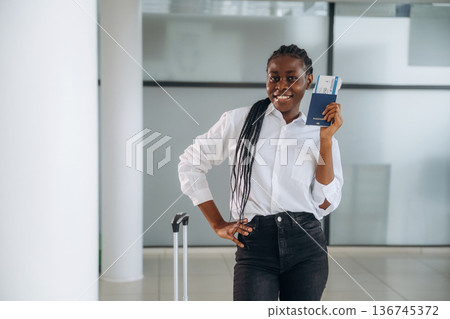 About to travel, airline board pass, ticket. Businesswoman in formal clothes is in the modern room About to travel, airline board pass, ticket. Businesswoman in formal clothes is in the modern room 136745372