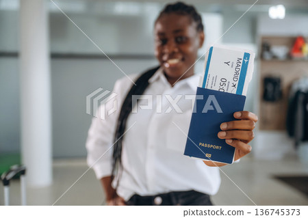 About to travel, airline board pass, ticket. Businesswoman in formal clothes is in the modern room About to travel, airline board pass, ticket. Businesswoman in formal clothes is in the modern room 136745373