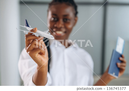 Female traveler in formal clothes is in the modern room. With tickets Female traveler in formal clothes is in the modern room. With tickets 136745377