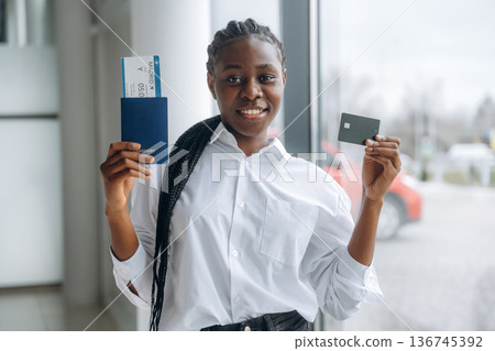 Vacation time, airport, with tickets. Businesswoman in formal clothes is in the modern room 136745392