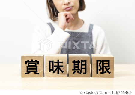 A woman in an apron and a block with the word "best before" written on it 136745462