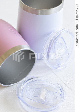 Two open stainless steel insulated wine tumblers with transparent lids on white, product showcase 136745725
