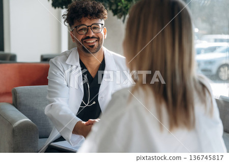 Consultation with doctor. Man and woman are indoors in modern building Consultation with doctor. Man and woman are indoors in modern building 136745817