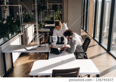 The notebook with plan. Man and woman are indoors in modern building The notebook with plan. Man and woman are indoors in modern building 136745837