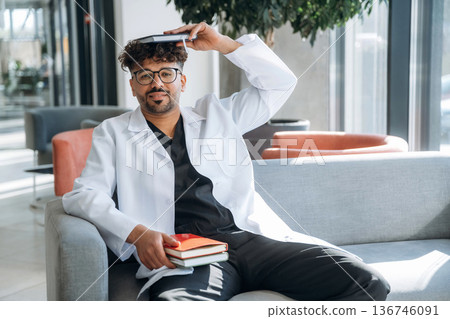 Books with learning information. Man is indoors in the modern building 136746091