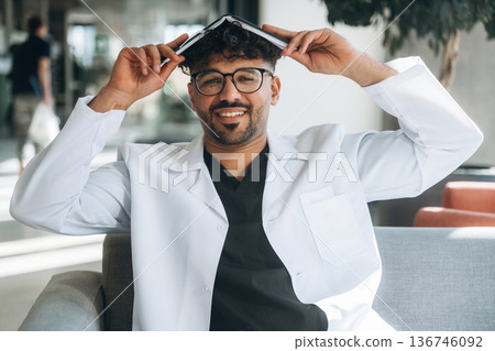 Books with learning information. Man is indoors in the modern building Books with learning information. Man is indoors in the modern building 136746092