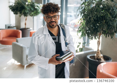Man is indoors in the modern building 136746100
