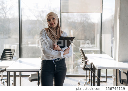 One person, front view. Muslim woman in hijab is in the office 136746119