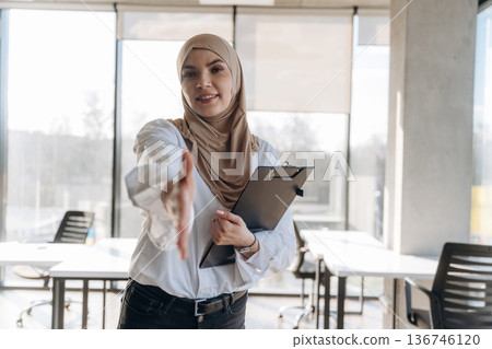 One person, front view. Muslim woman in hijab is in the office One person, front view. Muslim woman in hijab is in the office 136746120