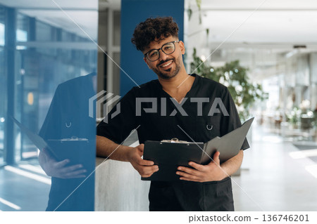 Smiling, cheerful facial expression. Male doctor is indoors in the modern building 136746201