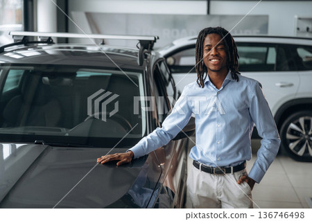 Front view. Car seller, businessman is standing in automobile salon Front view. Car seller, businessman is standing in automobile salon 136746498