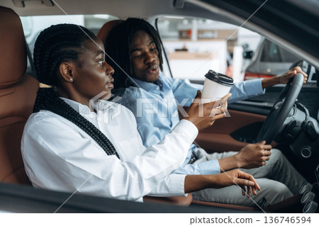 Sweet couple. Man and woman are in the automobile 136746594