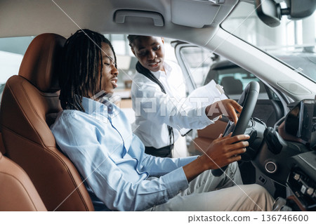 Testing the comfortable seats. Man and woman are in the automobile Testing the comfortable seats. Man and woman are in the automobile 136746600