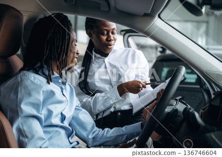 Trying the feel of vehicle. Man and woman are in the automobile Trying the feel of vehicle. Man and woman are in the automobile 136746604