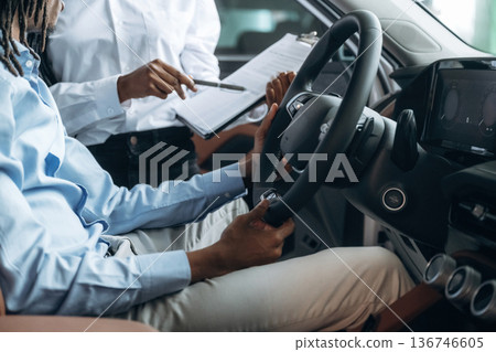 Trying the feel of vehicle. Man and woman are in the automobile 136746605
